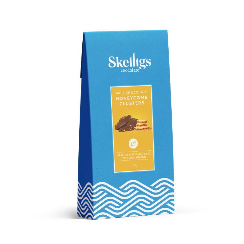 A blue stand-up pouch of Skelligs Chocolate Milk Chocolate Honeycomb Clusters, featuring a yellow label with an image of the chocolate clusters and blue wave patterns at the bottom, set against a plain white background.