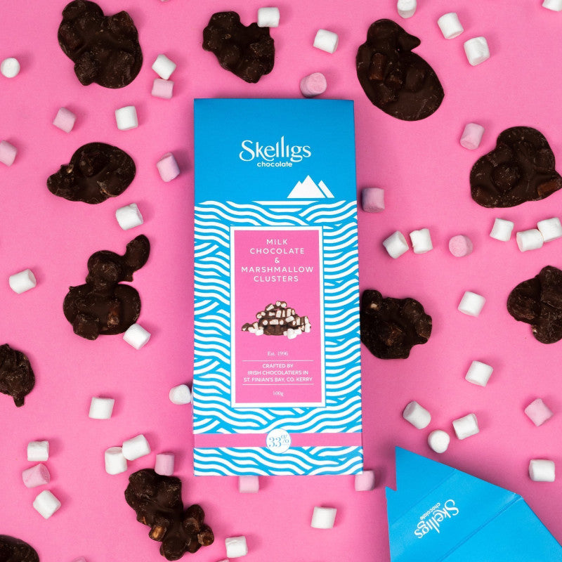 Skellings chocolate bar packaging on a pink background with chocolate clusters and marshmallows.