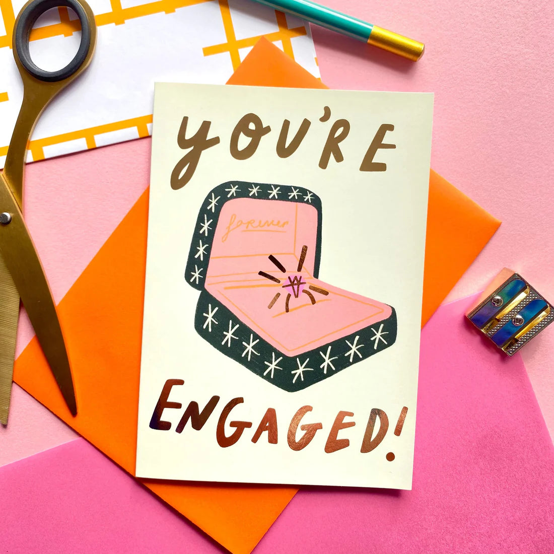 A6 Card with hand-written "You're engaged!" text, ring box illustration and an orange envelope